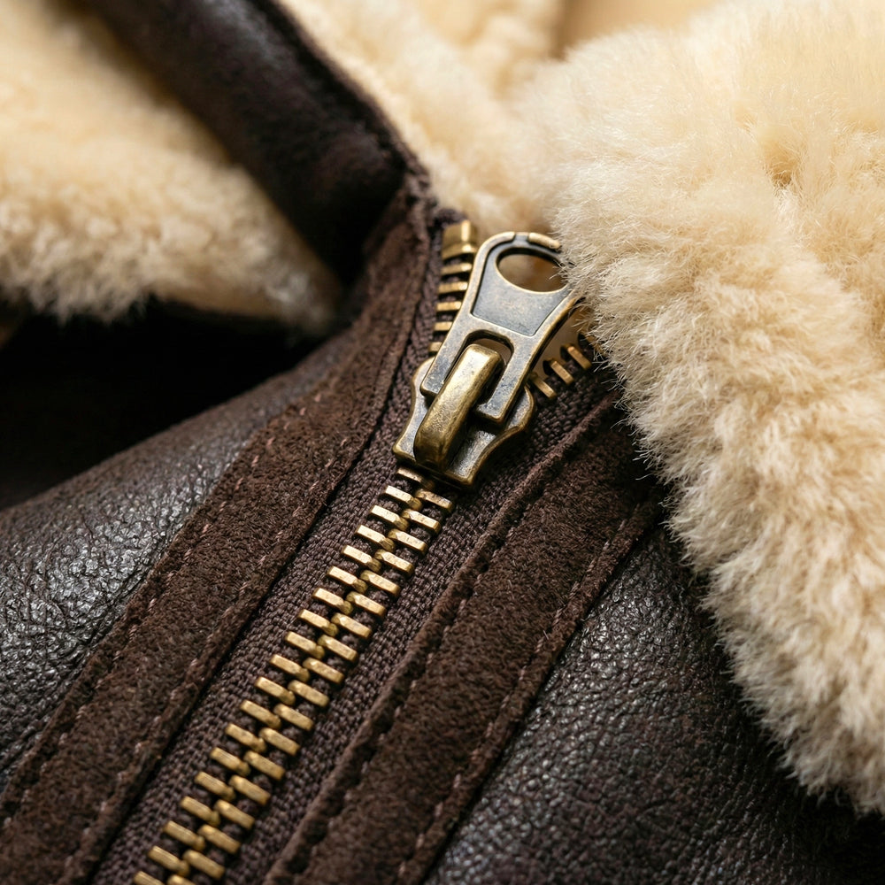 High-definition close-up of the premium metal asymmetrical zipper and artisanal double-stitching on a handcrafted brown leather winter coat.